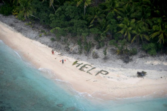 Two of three men stranded on the uninhabited island of Fanadik in Micronesia wave life jackets as a U.S. Navy P-8A Poseidon maritime patrol and reconnaissance aircraft discovers them